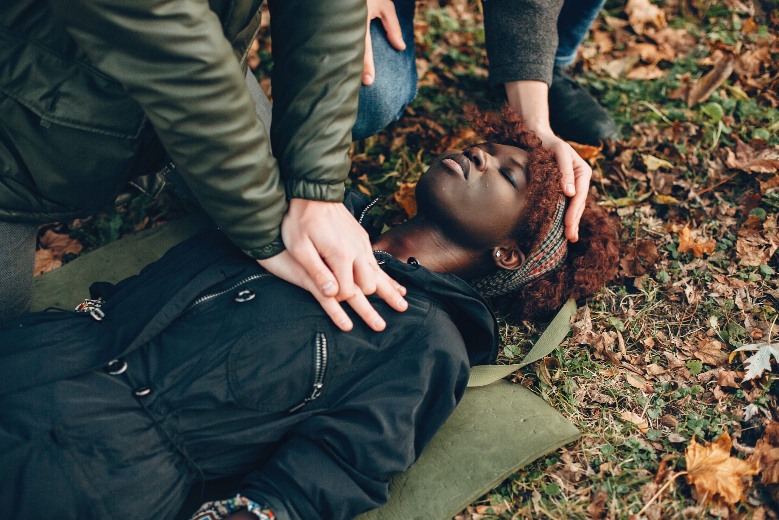 Bystanders administering immediate CPR and first aid in a community park